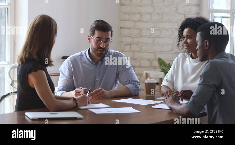 Diverse business team working in teamwork sit at conference table Stock