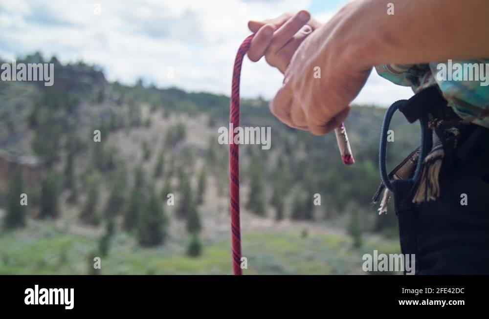 Medium close up shot of climbers hands tying rope to climbing