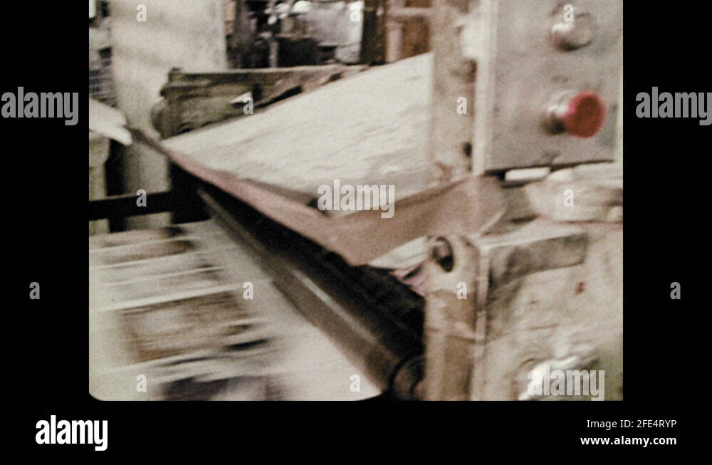 Printing press moves rapidly, man holds paper. Factory, roll of paper