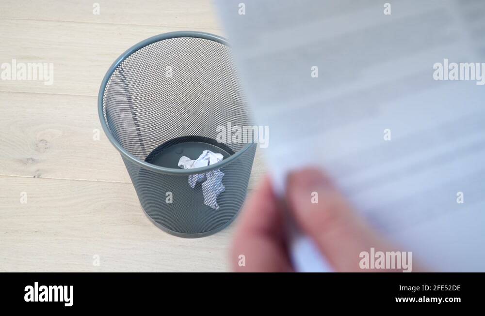 Office employee tossing away crumpled paper into trash can Stock Video