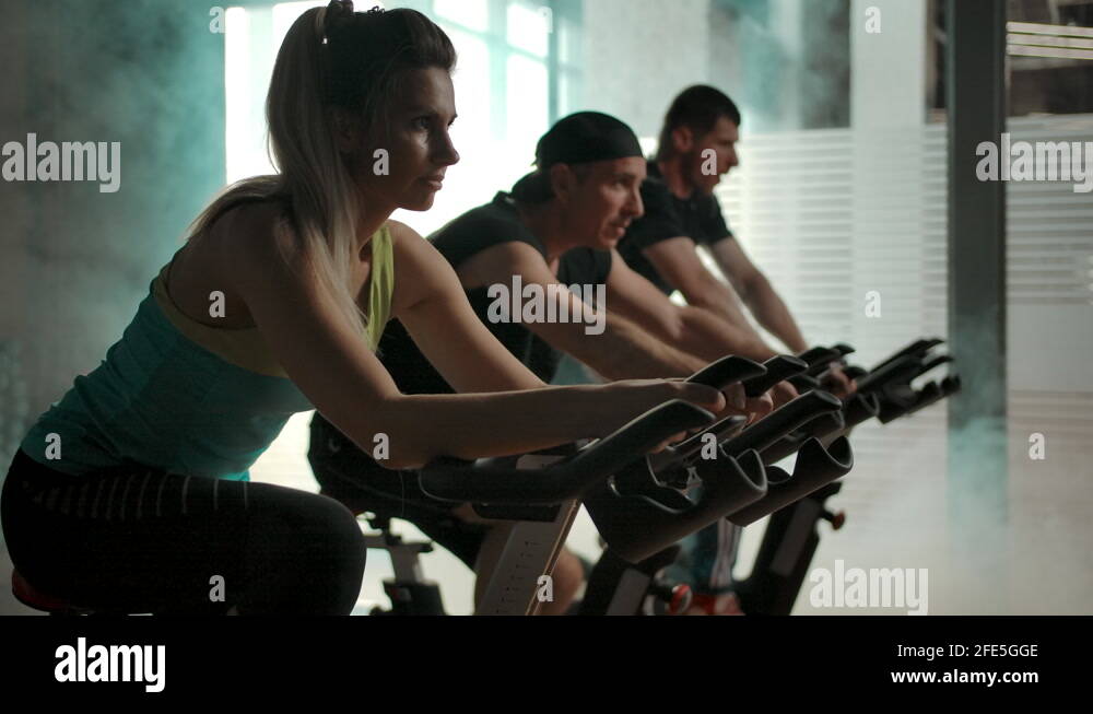 Athletes train the muscles of the legs on the exercise bike in the gym