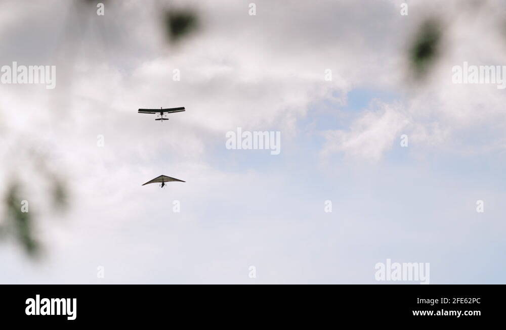 Airplane tows Hang Glider gaining altitude in clouds, tandem hang