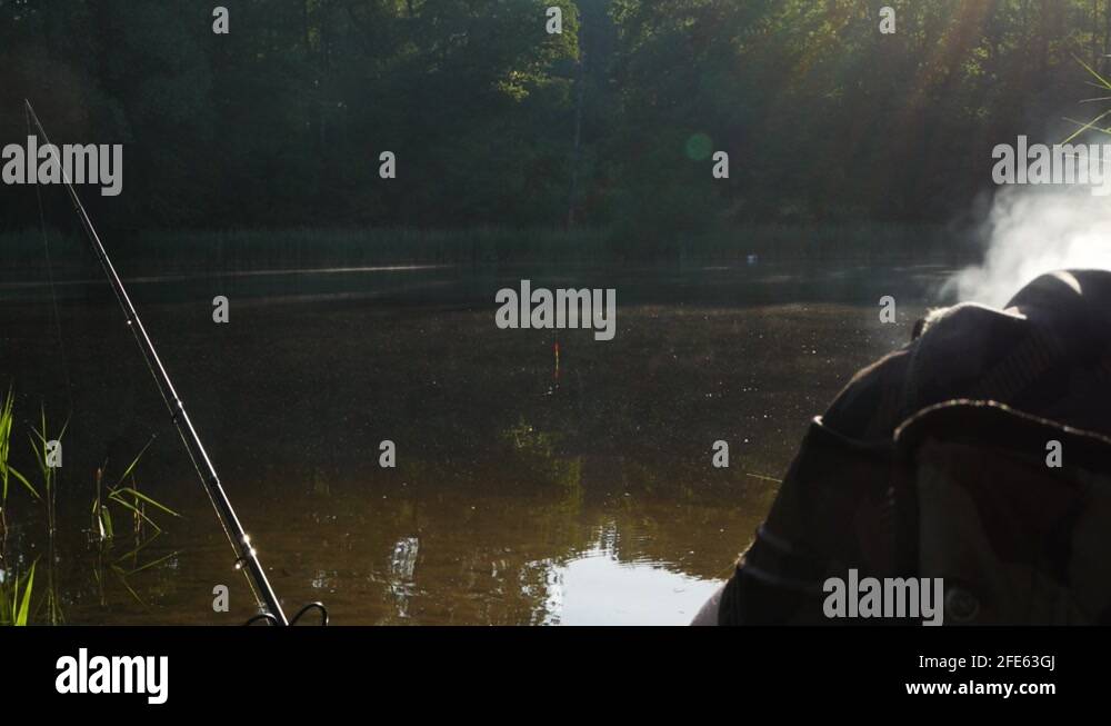 Fisherman fishing on the lake while smoking with white smokes coming