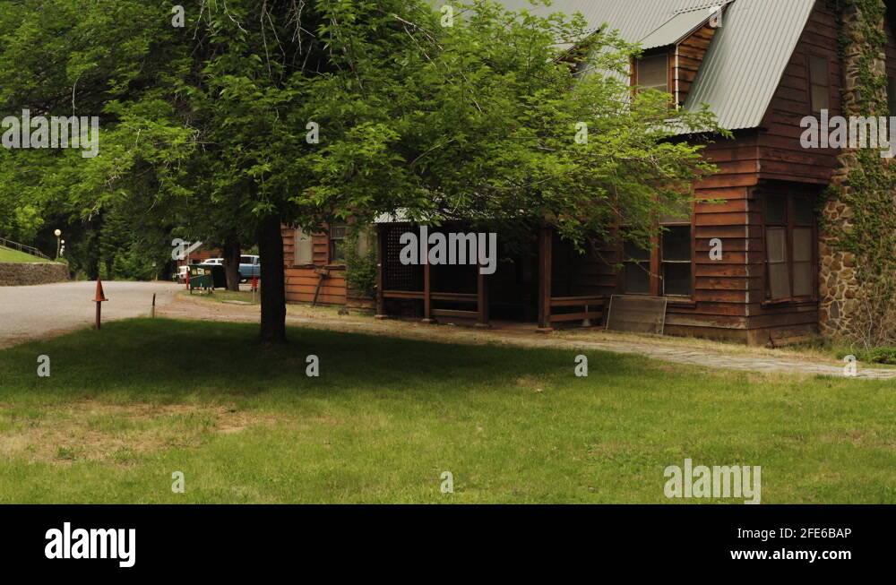 Wooden cabins in Plumas National Forest, low flying aerial backwards