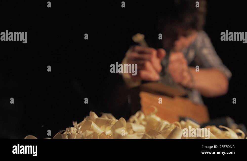 Carpenter hand planing pine timber shavings ejecting slow motion Stock
