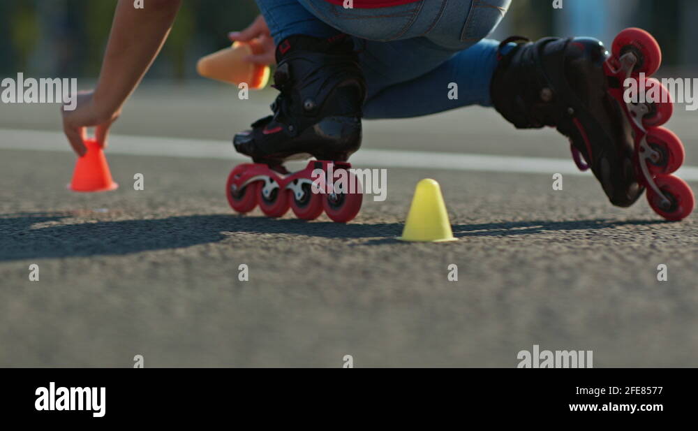 Roller skating on asphalt and placing cones, marking the track. Roller
