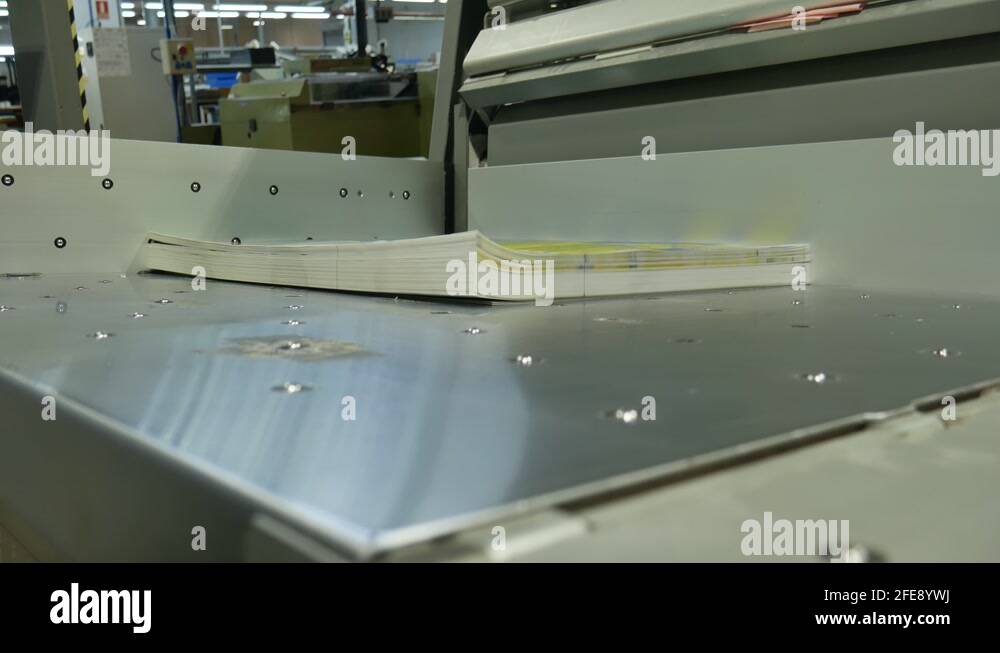 worker prepares a run of labels to cut them to exact measurements ...