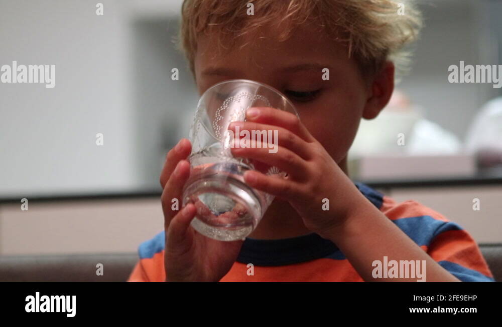 Toddler child drinking water. Kid drinks last sips of water during meal