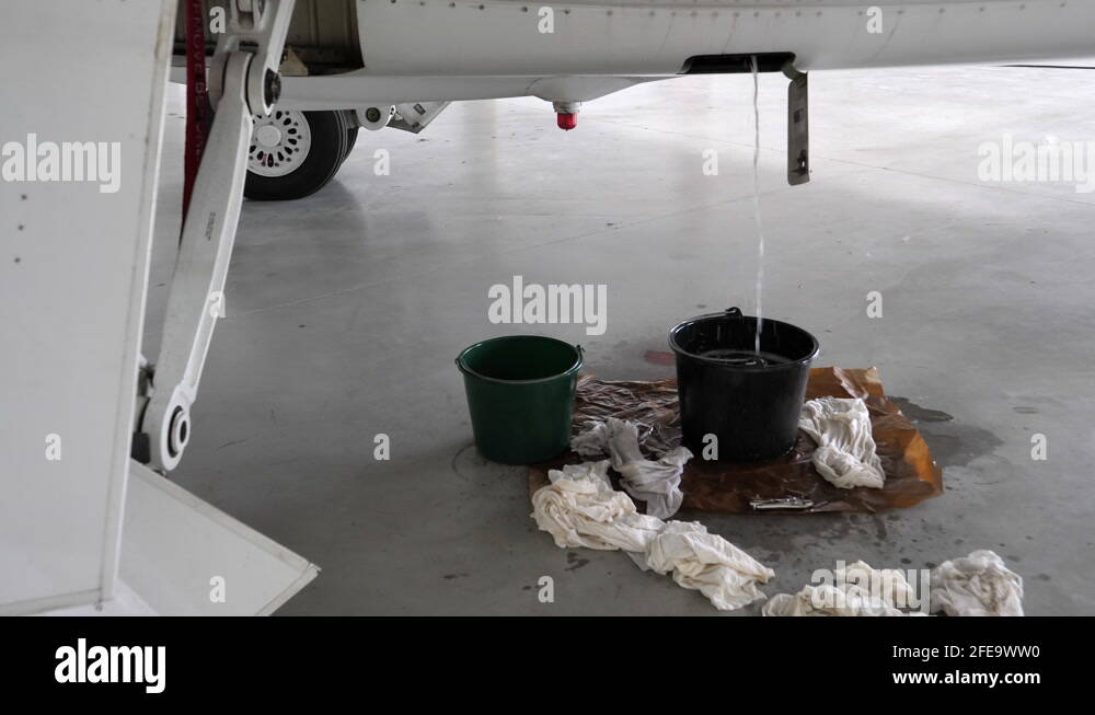Kerosene Fuel Draining out of Hangared Aircraft's Drain in Bucket Stock