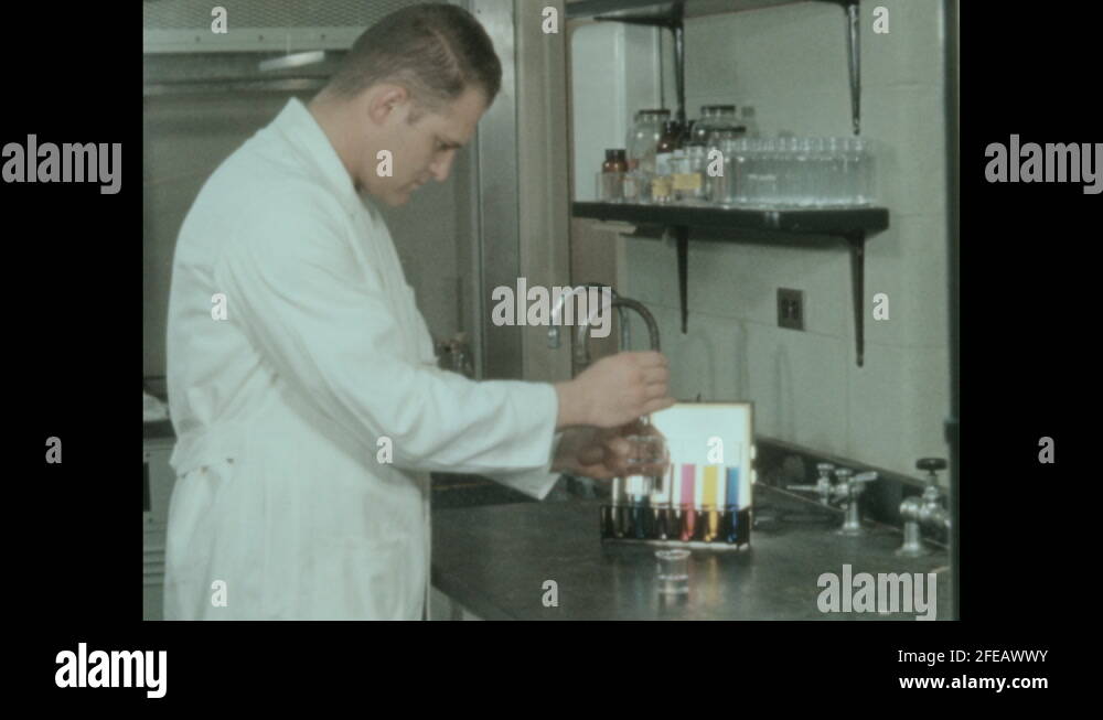1950s Laboratory, man in white lab coat mixes beaker of pink liquid