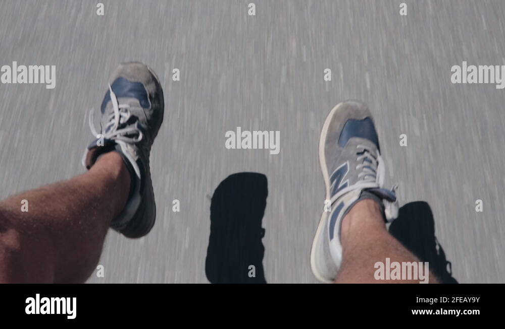 Guy hanging down his feet sitting on back of pickup truck driving down