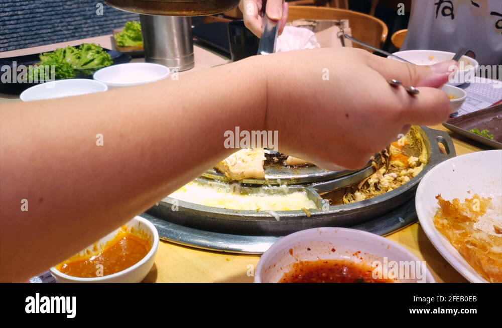 Korean hot plate barbeque with various cuts of meat and melting cheese