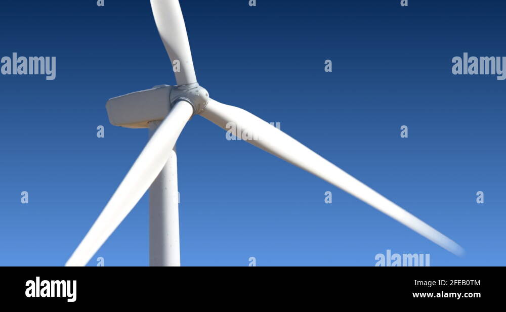 Close up, side view of a rotaing wind tower turbine electricity ...