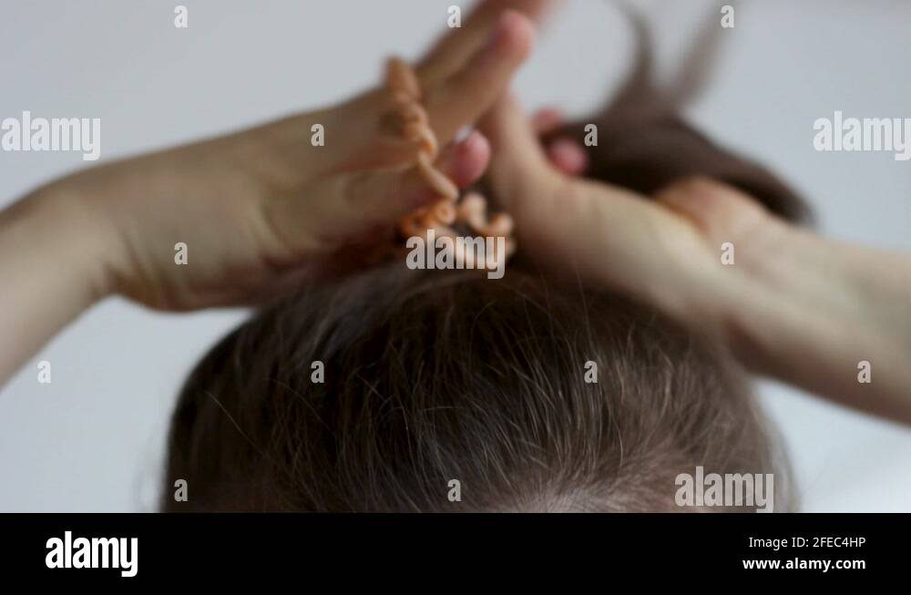 Girl doing her own hair closeup on white background Stock Video