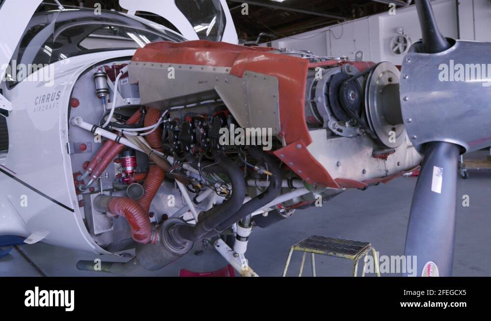 Single prop plane in hangar with cowl red, pan around Stock Video