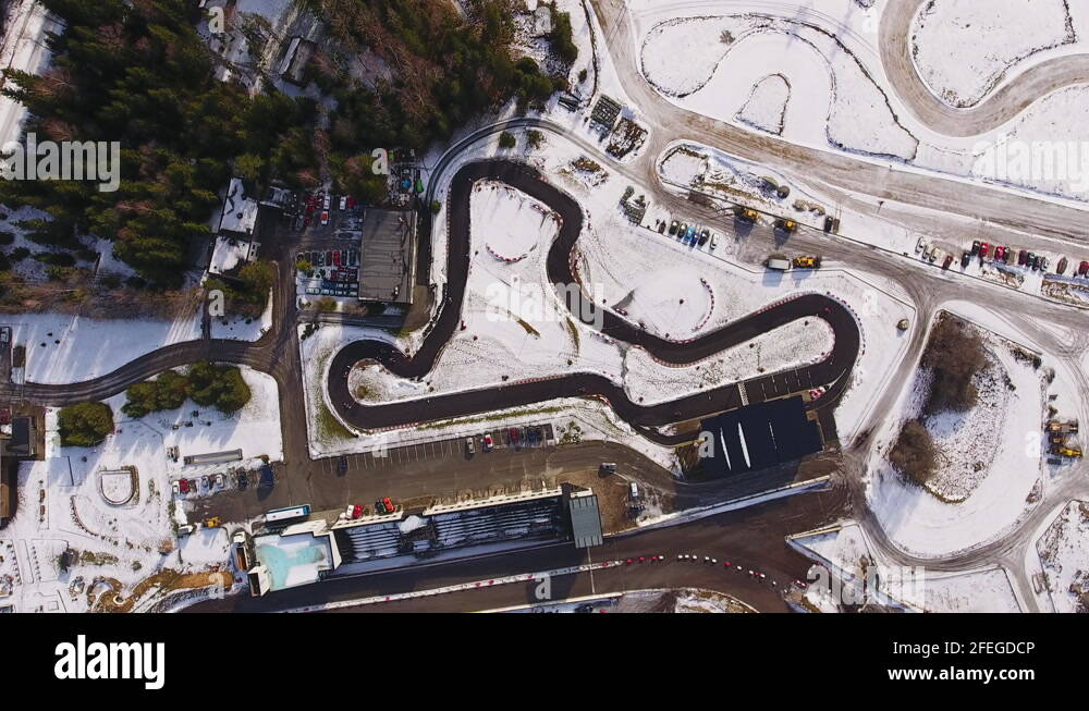 Gokarts racing on Laitse Rally Park asphalt track during winter with snow Stock Video Footage