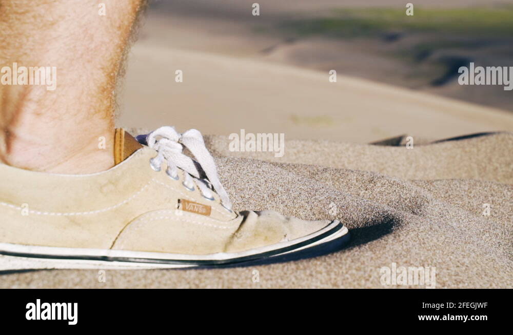 Male Sneaker with a vans shoe walking in sand, sunny day, in The great
