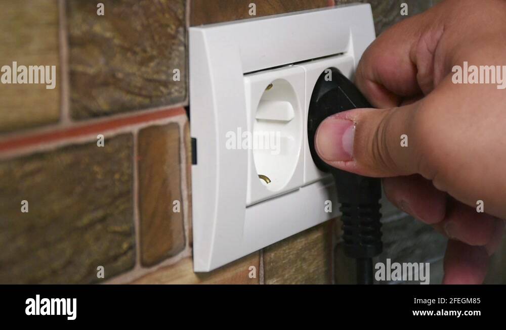 Sideways view of a dual power outlet. Connecting and disconnecting a black Stock Video Footage