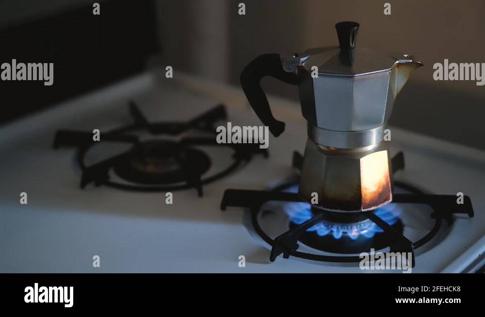 moka pot on gas burner of old stove lights in slow motion in morning