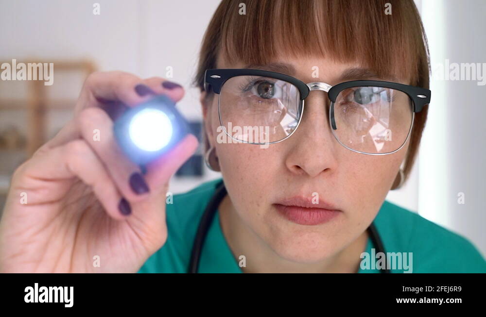 POV of female optometrist moving light back and forth to test eye muscles of Stock Video Footage