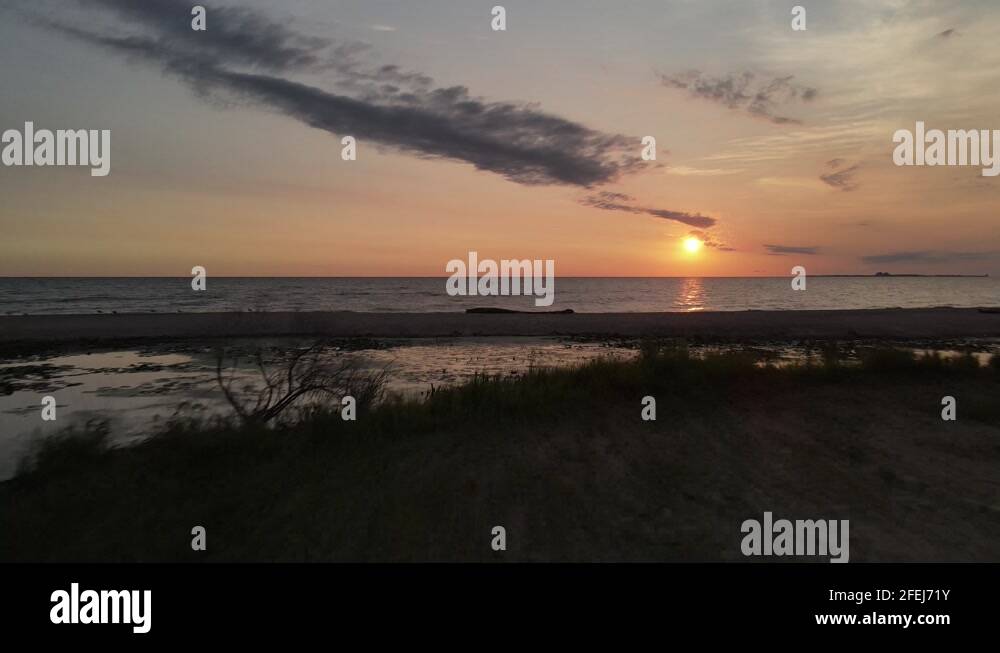 Sunrise over Lake Huron Michigan with driftwood on the beach Stock