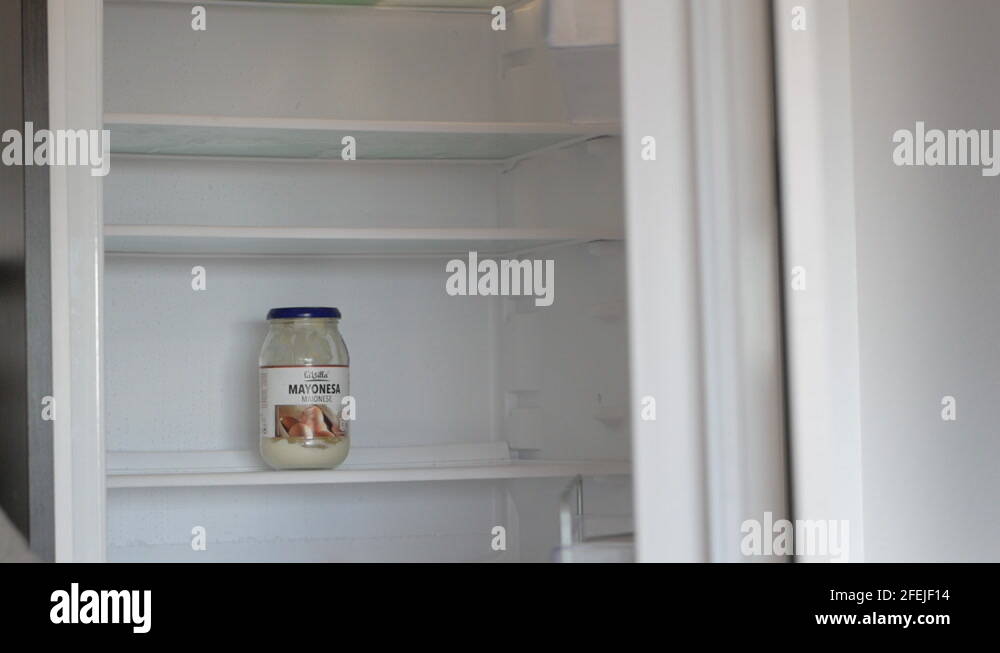 Opening Door Of Refrigerator With A Jar Of Mayonnaise Inside close up