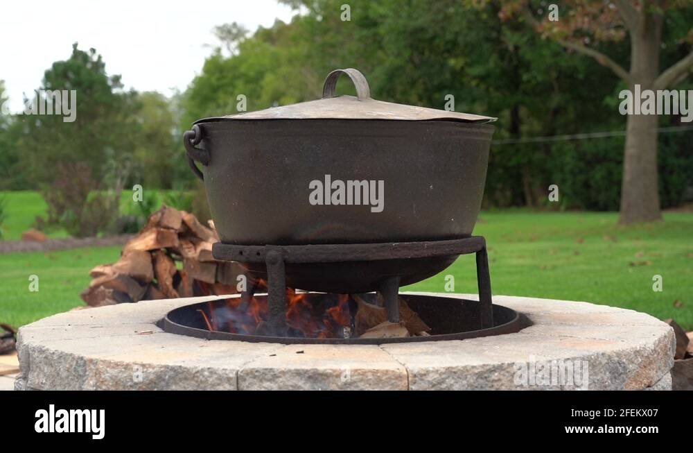 An old fashioned iron kettle over the fire of an outdoor campfire Stock Video Footage Alamy