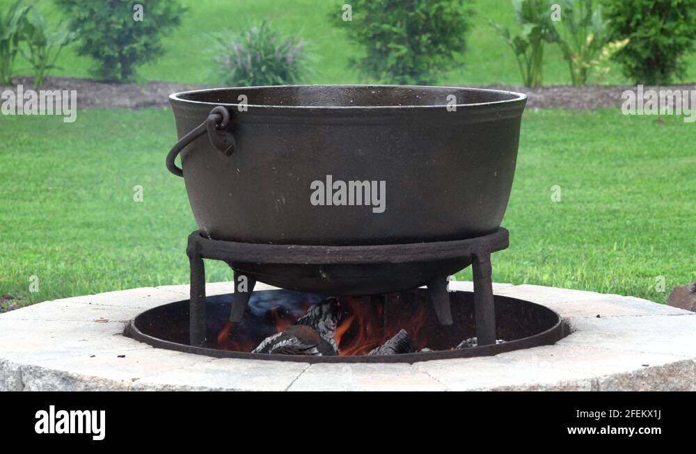 An old fashioned iron kettle over the fire of an outdoor campfire Stock ...