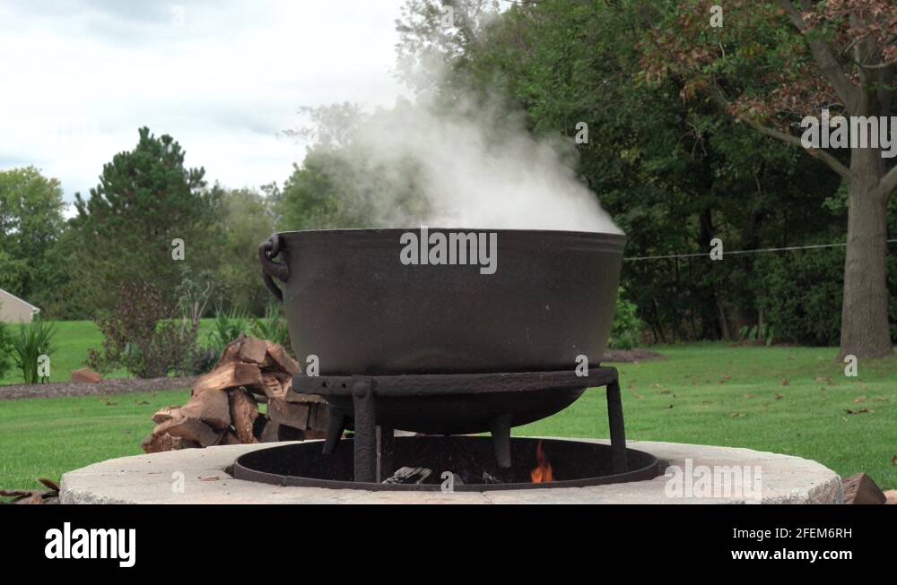 An old fashioned iron kettle over the fire of an outdoor campfire Stock ...