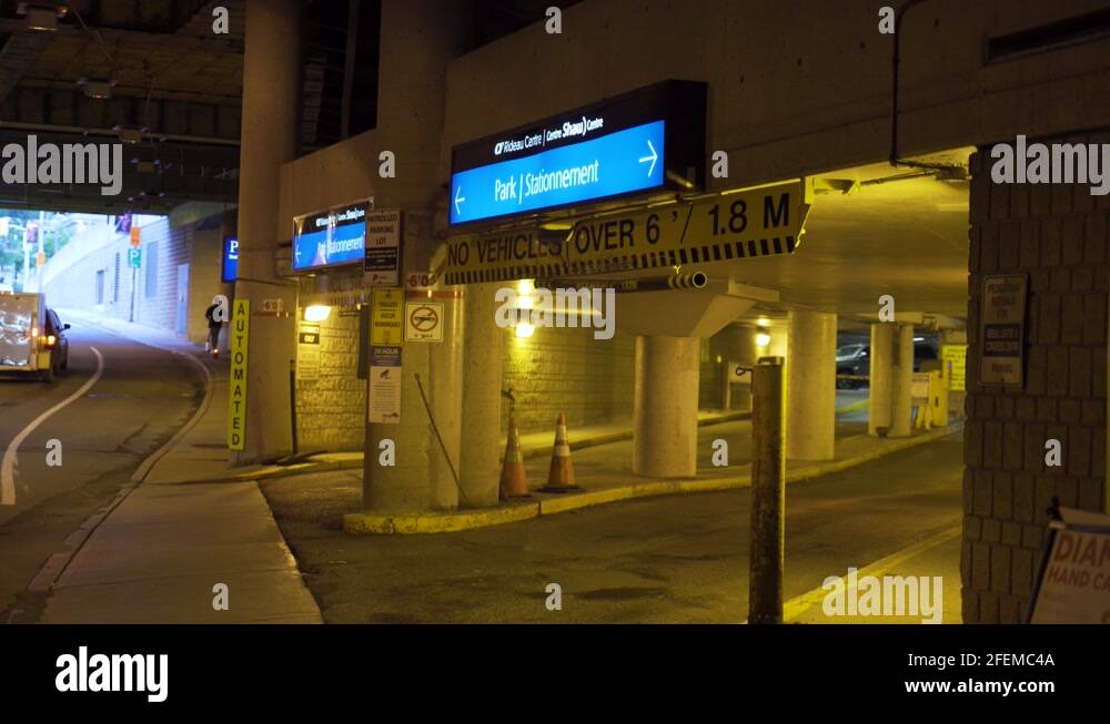 Underground parking garage entrance with exit and enter signs in blue
