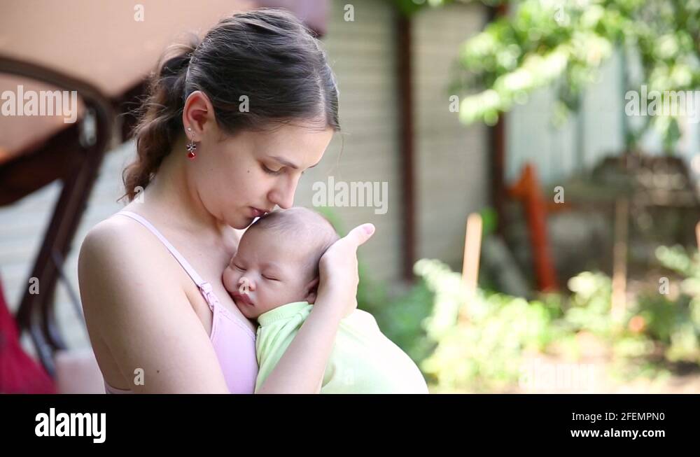 little baby boy sleeping on mom's chest outdoor Stock Video Footage Alamy
