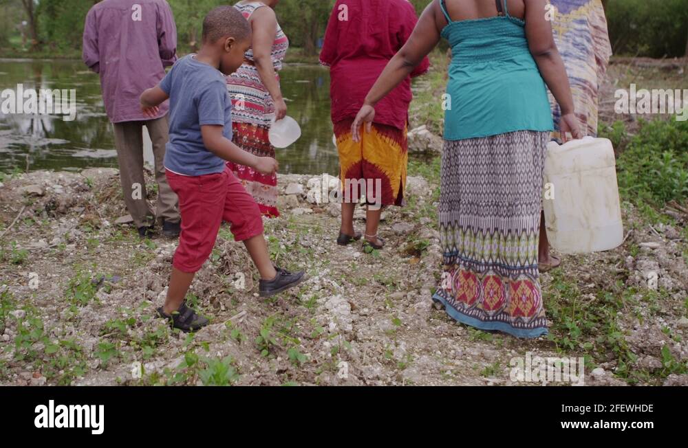 African villagers at river fill containers with as much water as they