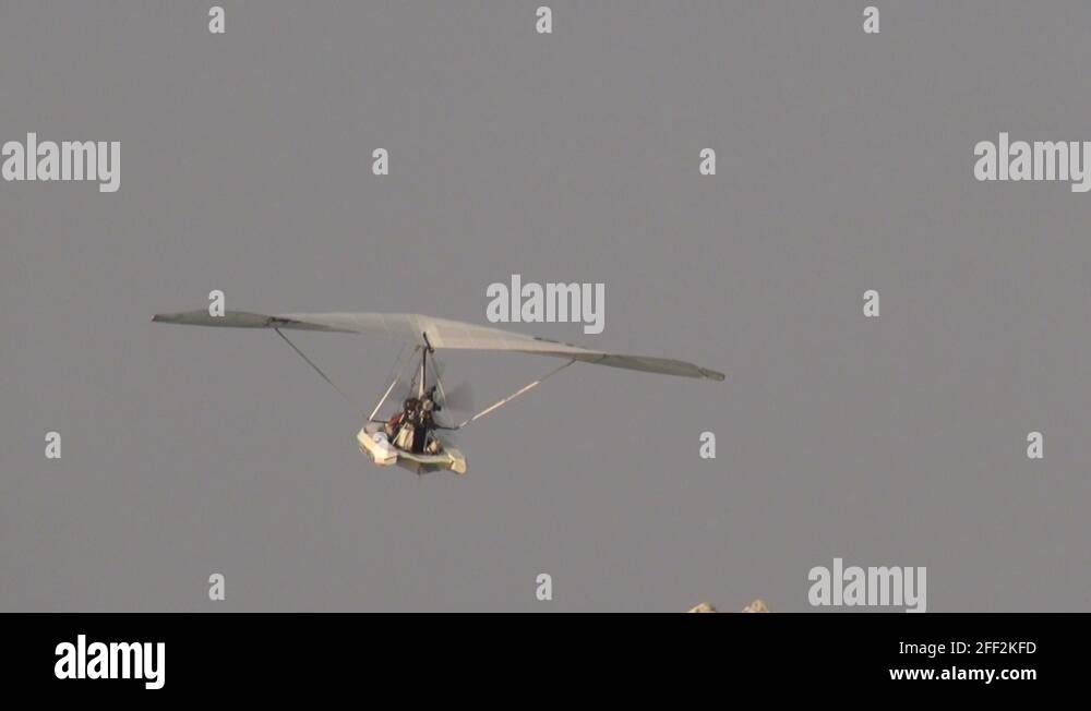 Hang glider flying at sunset, powered delta plane, tourist flight Stock