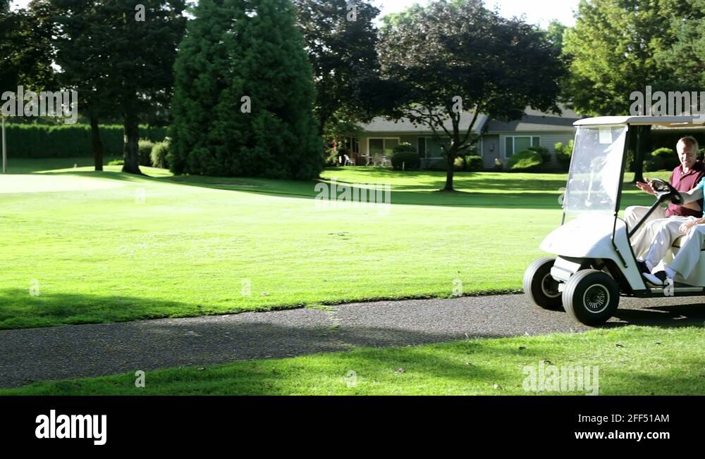 Golfing buddies ride in a golf cart together Stock Video Footage Alamy