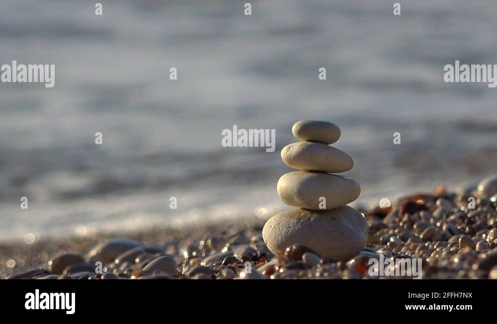 Sea wave on the beach breaking down building of overlapped stone