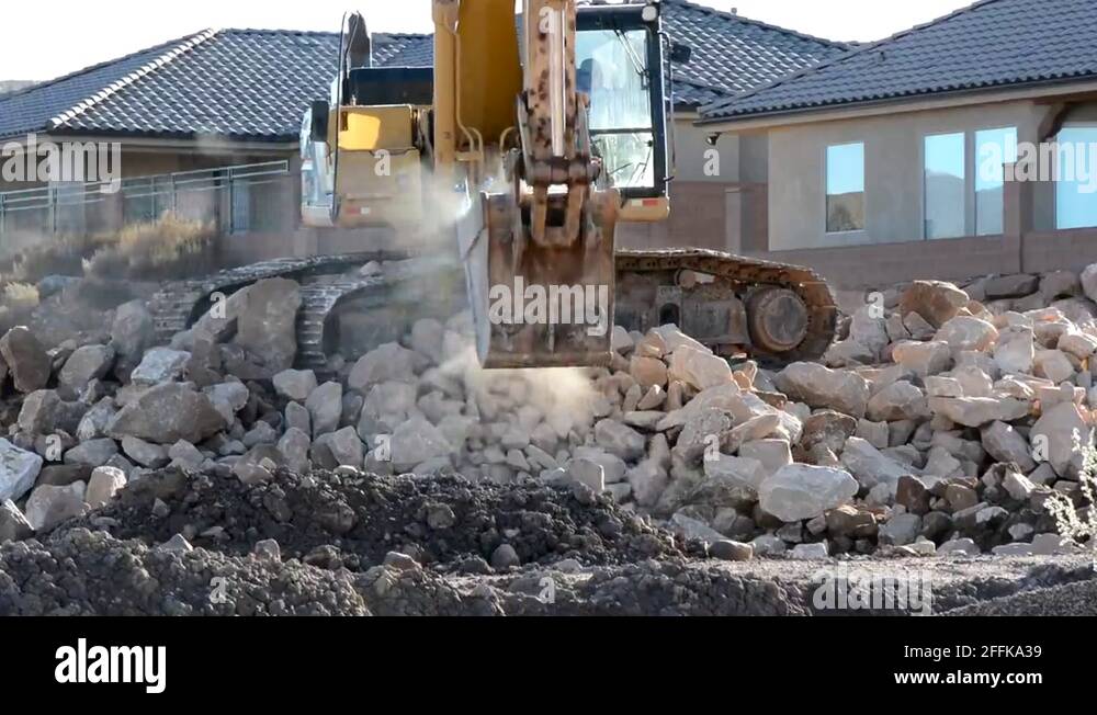 Excavator loading rocks and boulders into a truck Stock Video Footage ...