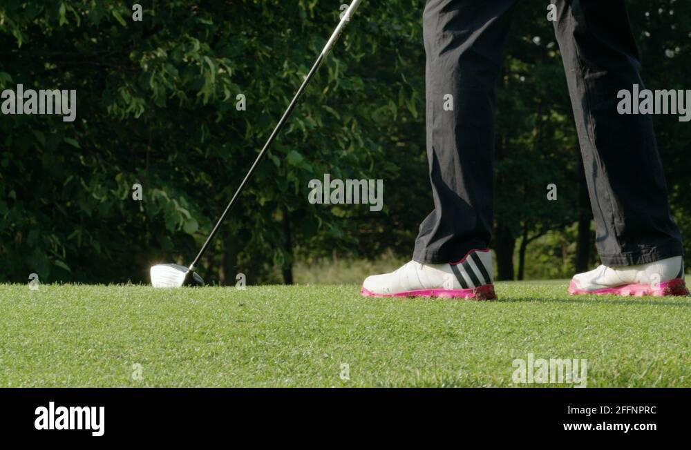 Low angle pan across golfers legs and club Slow motion Stock Video