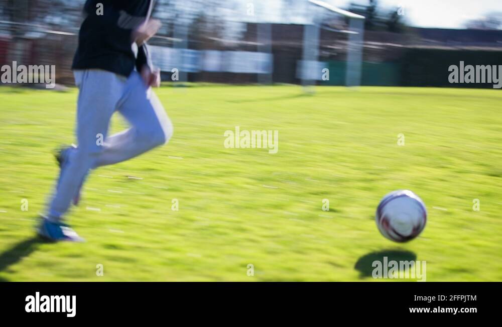 Running on soccer field and kicking ball Stock Video Footage Alamy