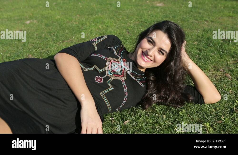 Young happy beautiful woman lying on grass and look at camera Stock ...