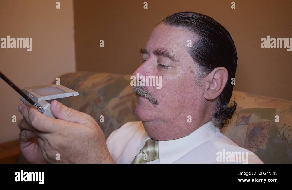 MAN WATCHING TINY TV old miniature portable TV receiver Stock Video