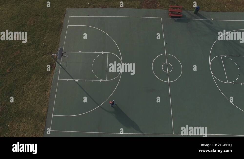 Boy missing shots on basketball court aerial view 4k Stock Video