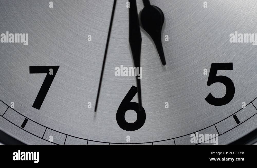 Slow zoom into a clock face as time counts down to 530 Stock Video