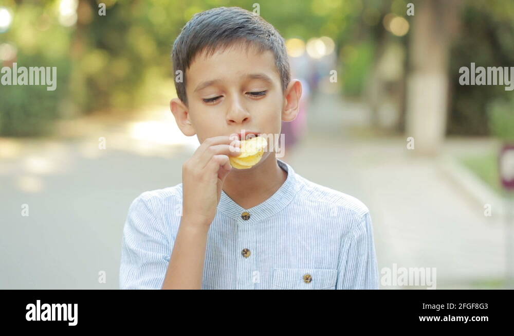 boy eating potato chips on the street. Teen boy eating junk food Stock ...