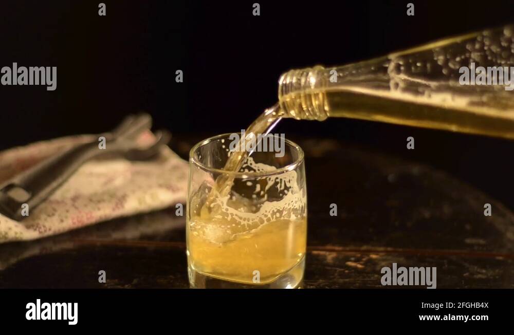 Beer is poured into a glass from the bottle Stock Video Footage Alamy