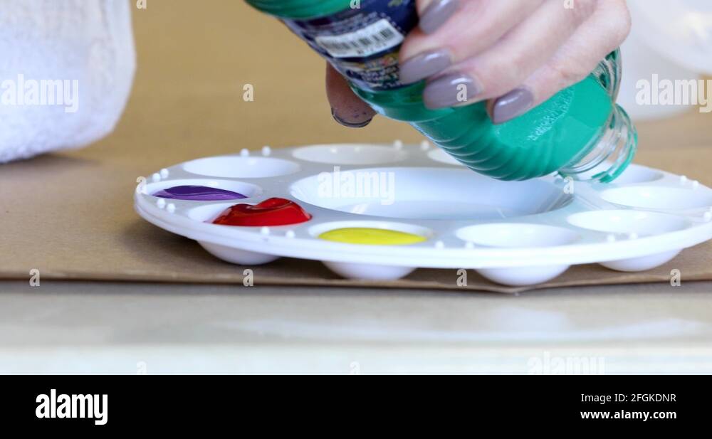 Extreme close up of teal paint being poured into a paint palette Stock