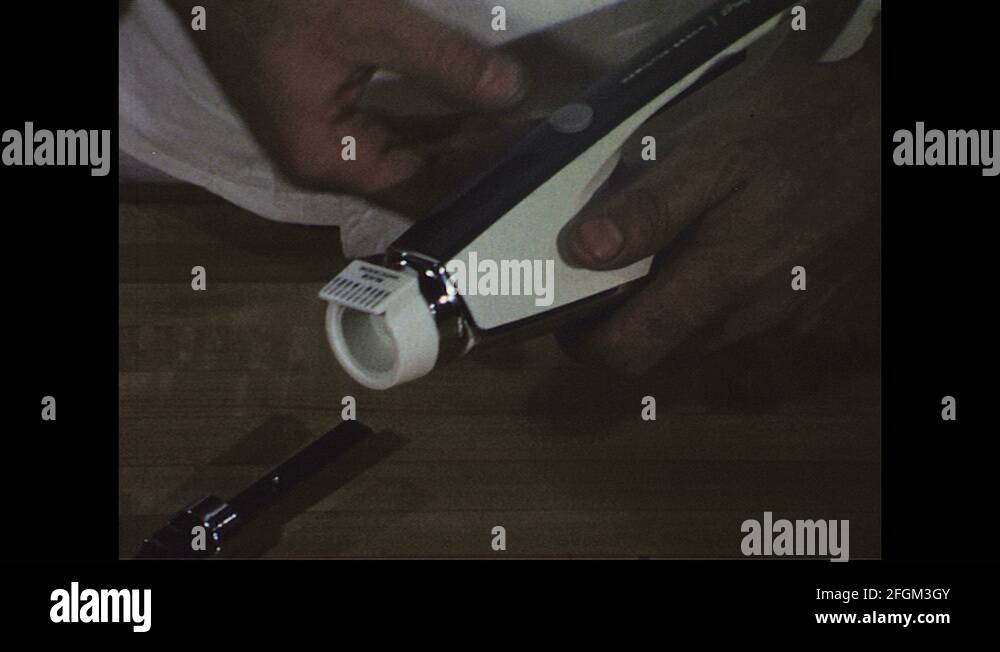 1960s Close up, hands display parts of electric knife / Knife cuts