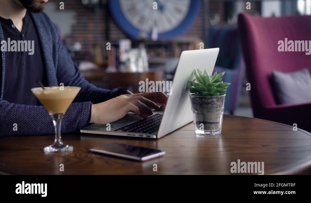 A young writer with a bad eye works for a laptop in his city's cafe, a man Stock Video Footage