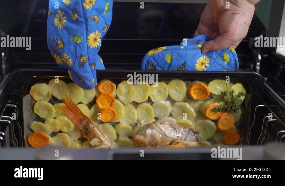 Woman cooking whole roasted fish rockfish baked in the oven top view