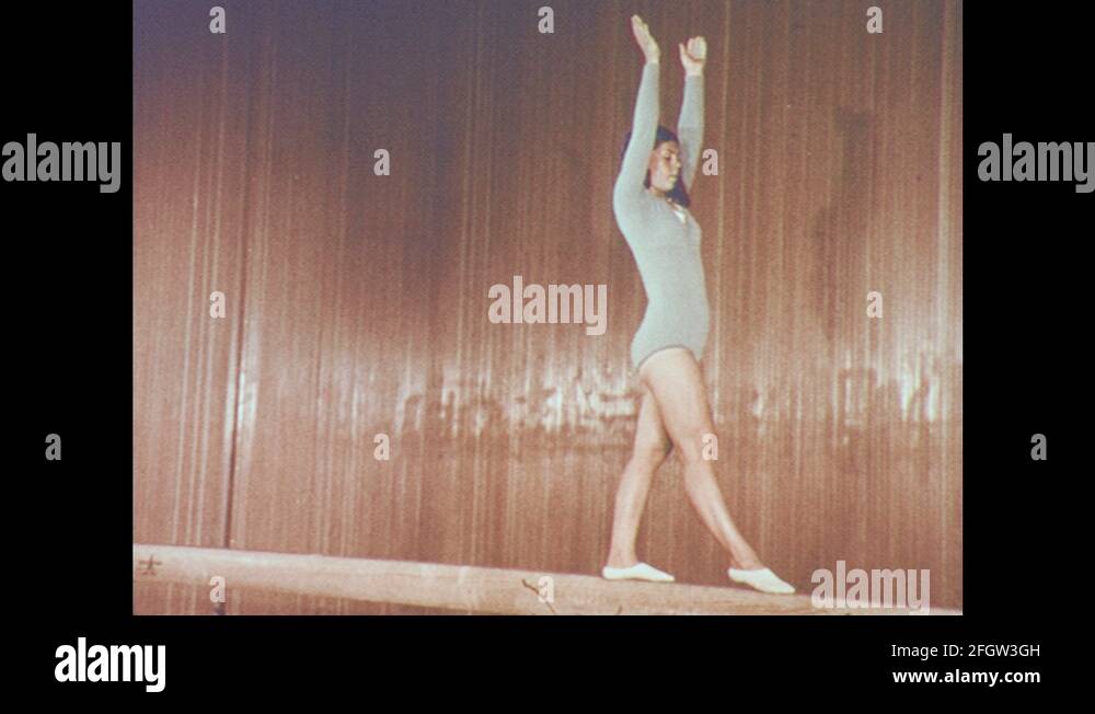1960s Young Woman Does Back Walkover On Balance Beam. Gymnast Does