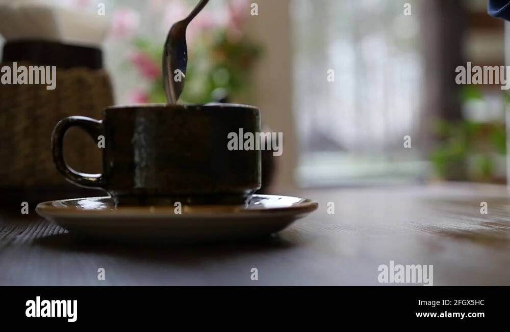 Stir hot tea or coffee in a cup, put a spoon on a saucer. slow motion